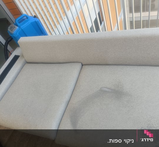 ספה עם כתם ומכונת ניקוי כחולה